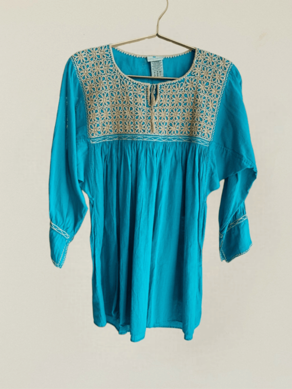 Esta hermosa blusa de algodón 100% en color turquesa es una muestra de la artesanía excepcional